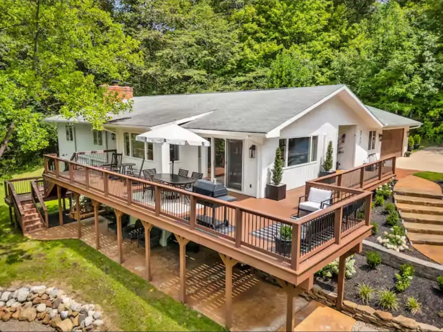 Large elevated wrap-around deck with stairs and paver patio below