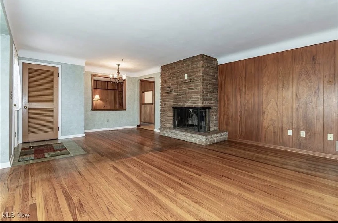 Living room with refinished hardwood floors and stone fireplace